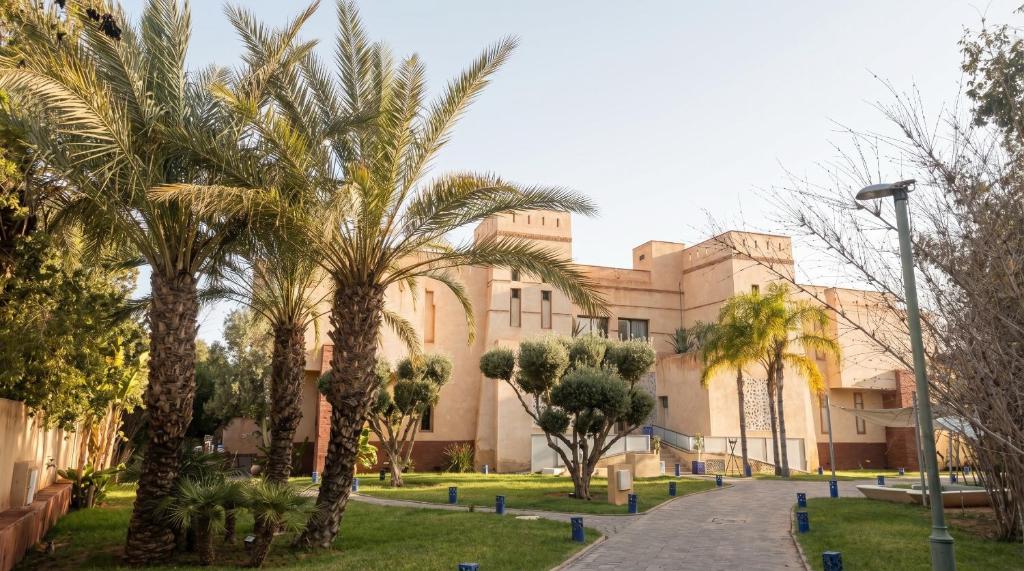 a building with palm trees in front of it at Villa AG Marrakech in Marrakesh