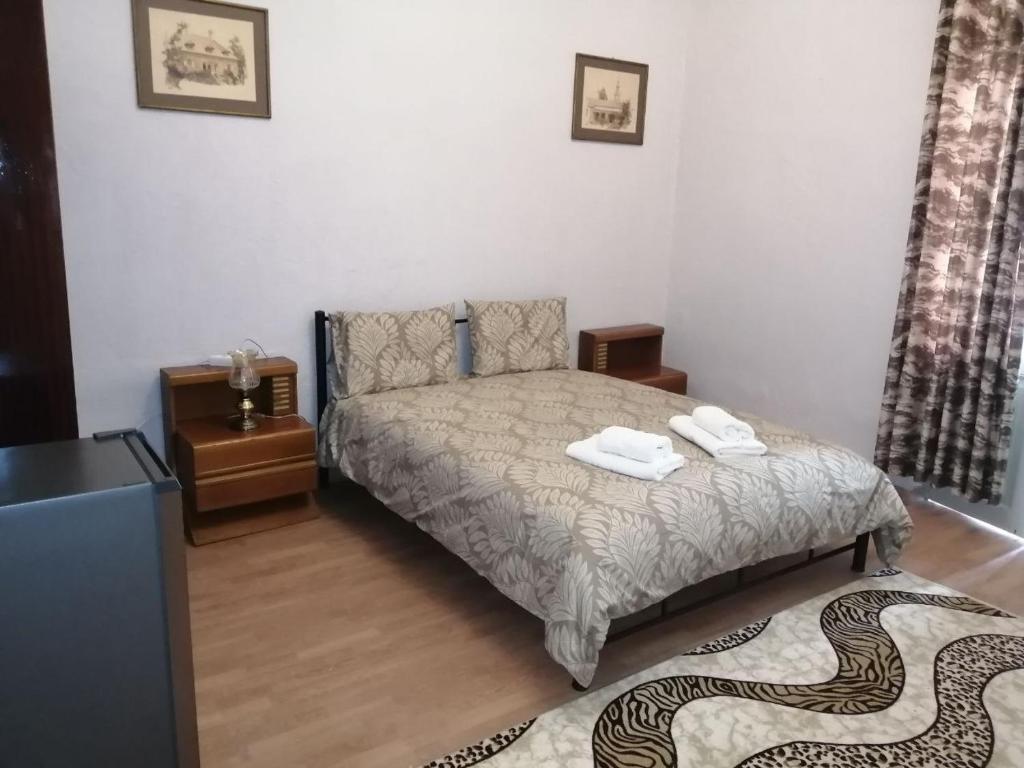 a bedroom with a bed with two towels on it at Courtyard Cottage in Athens
