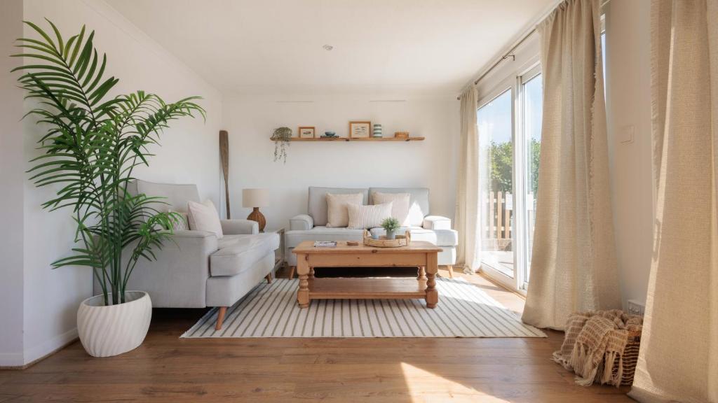 a living room with a couch and a table at Hot Tub With A View - Christchurch Harbour in Christchurch