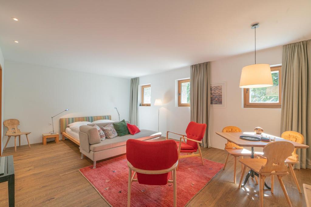a living room with a couch and a table and chairs at Chesa Piol Studio in Maloja