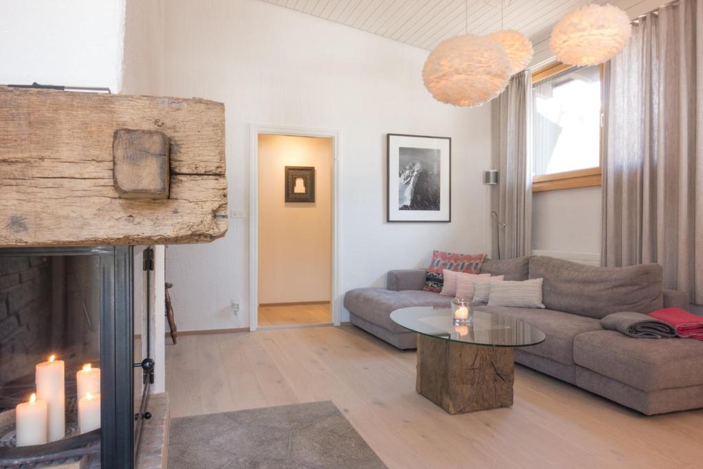 a living room with a couch and a fireplace at Chesa Maria 7 in Sils Maria