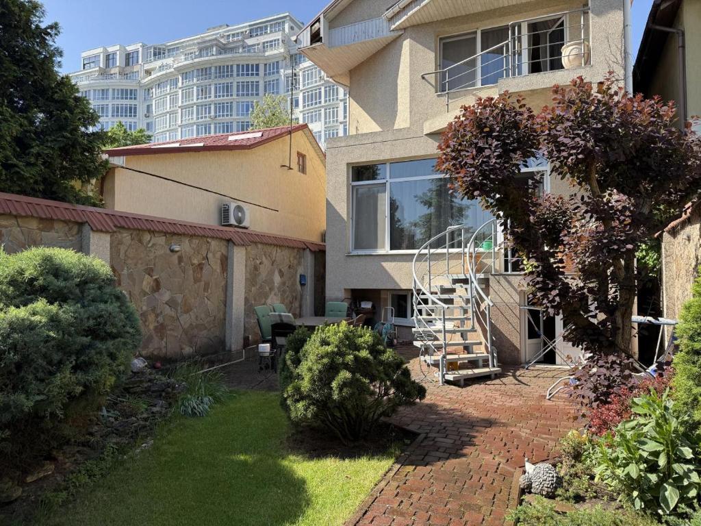 a apartment building with a patio and a staircase in a yard at Дом в Аркадии - море рядом! in Odesa