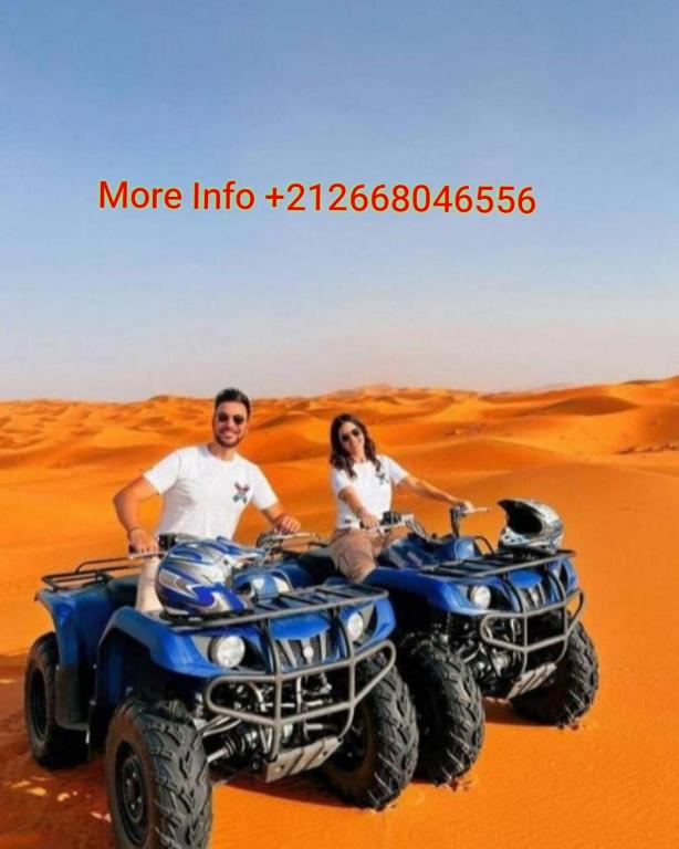 a man and woman riding atvs in the desert at Authentic Desert Luxury Camp in Merzouga