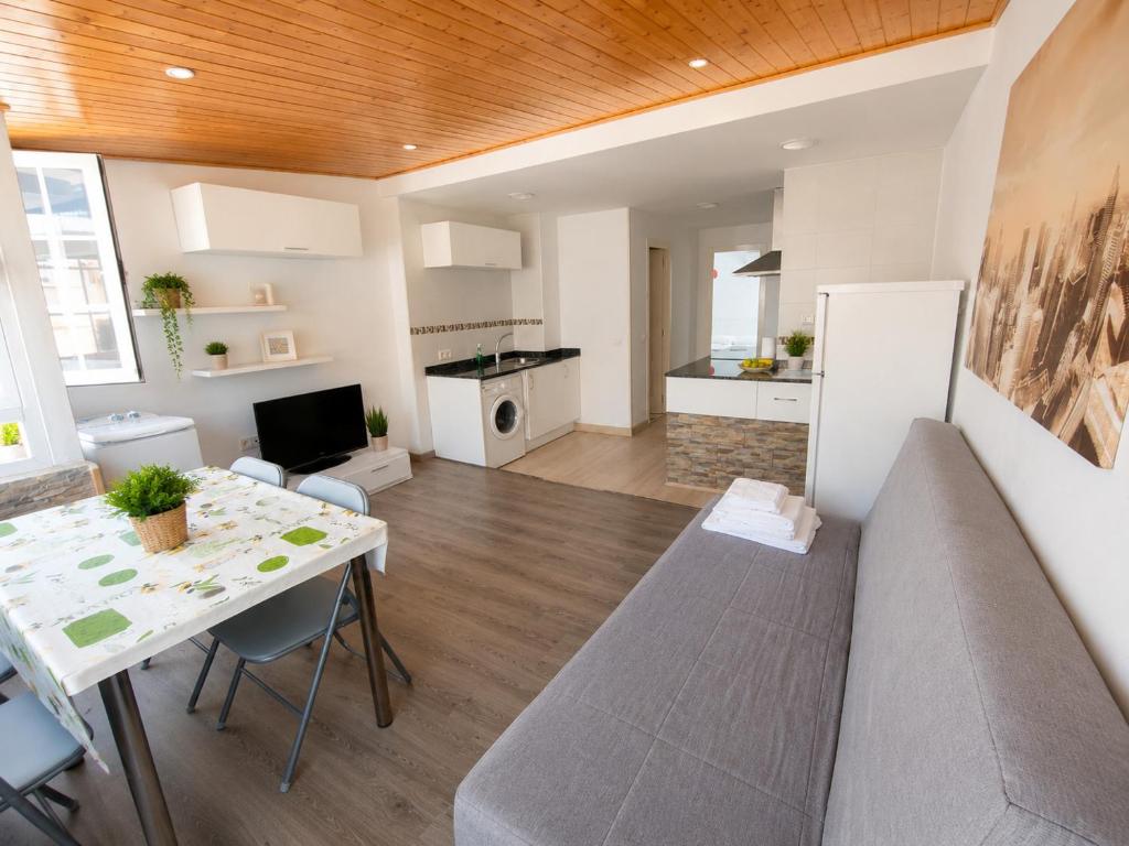 a living room with a table and a kitchen at AMAIKA AH Rentals in Peniscola