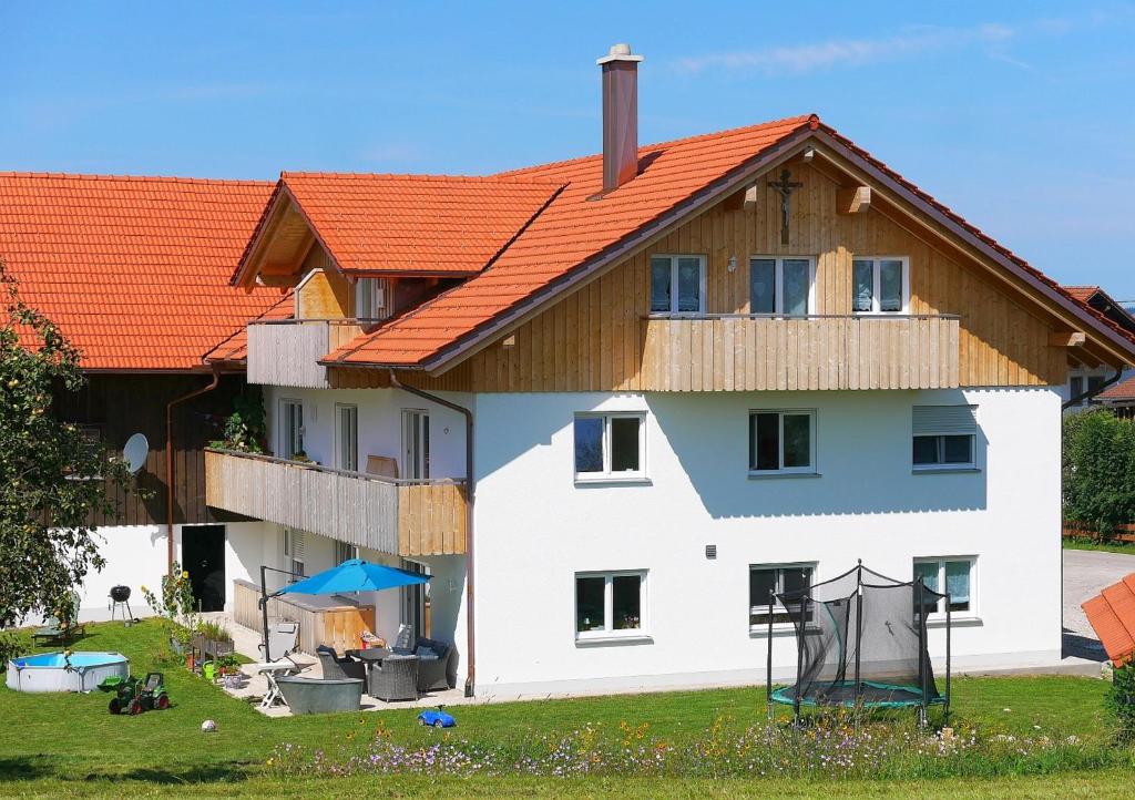 a large white house with an orange roof at Ferienwohnungen beim Sommermader - inklusive Königscard in Nesselwang