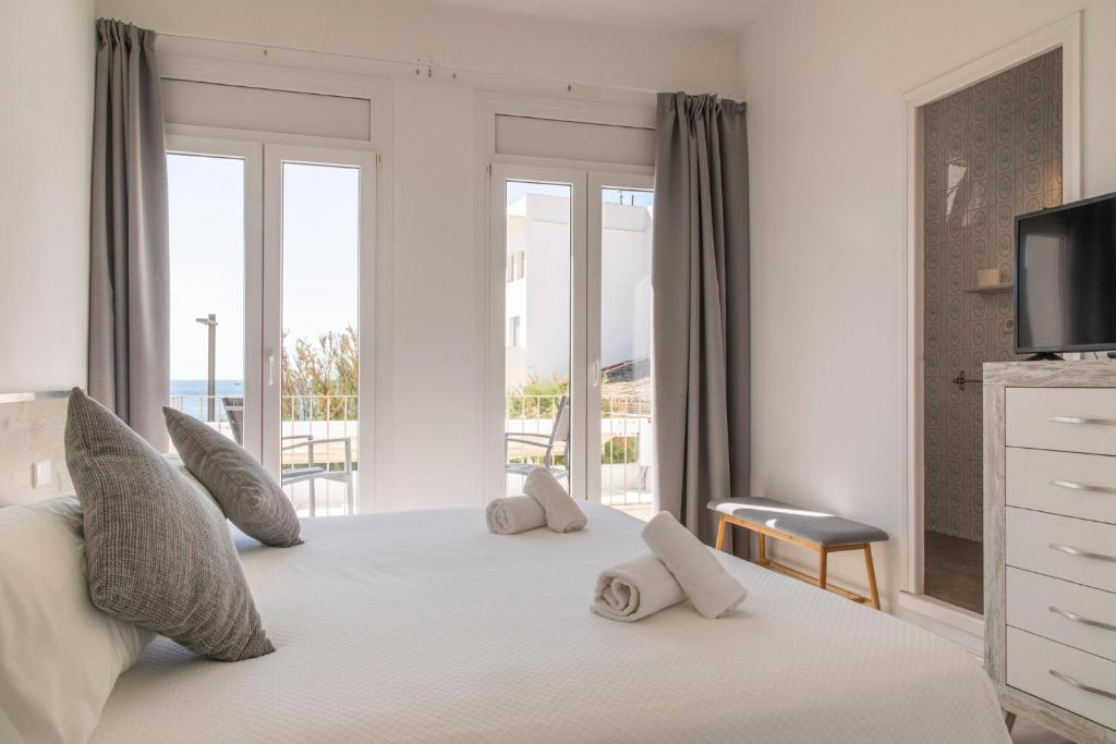 a bedroom with a large white bed with a balcony at Hostal La Llagosta in Llafranc