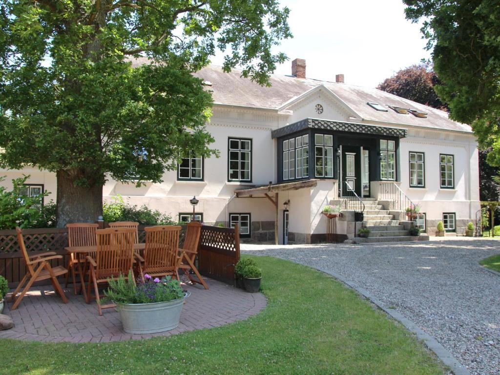 a house with chairs and a table in front of it at Hof Muhs in Stakendorf