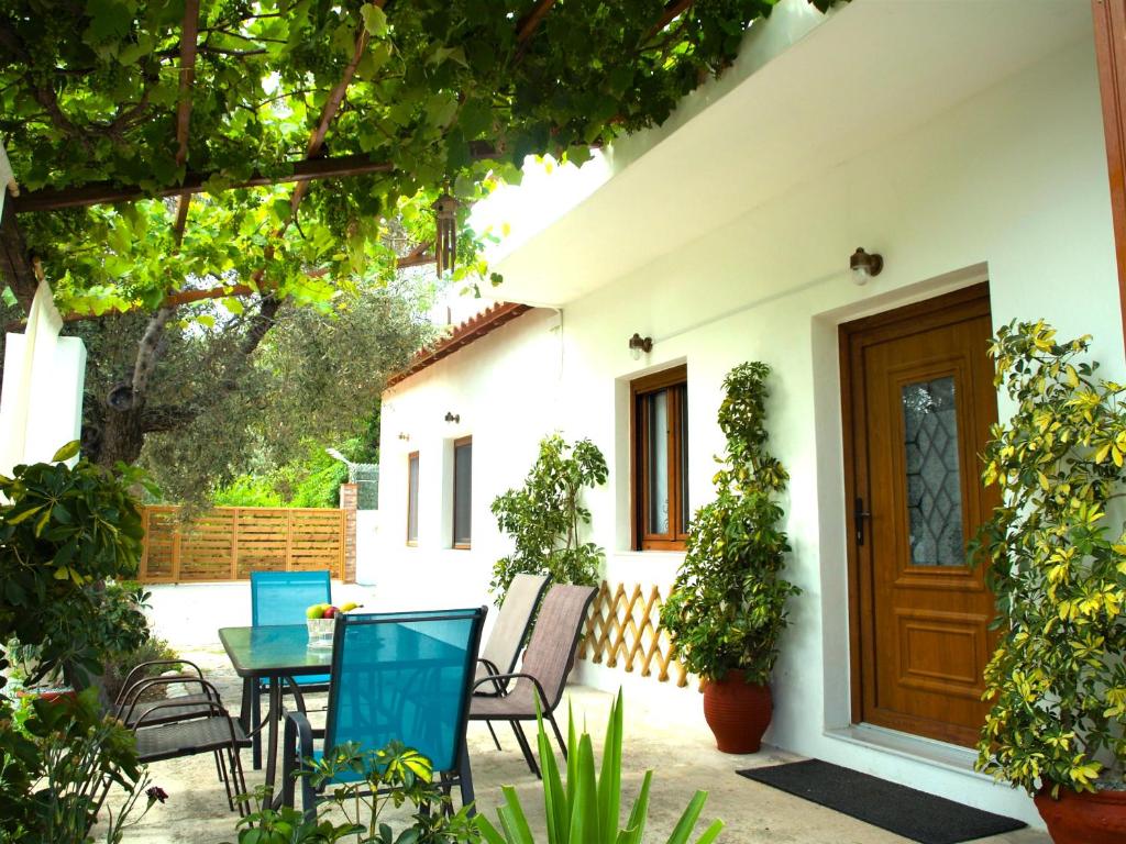 a patio with chairs and a table in front of a house at ilioni house in Skopelos Town