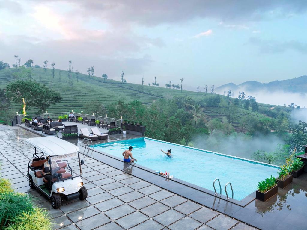 a pool at a resort with people in it at Elysian Vale in Vagamon