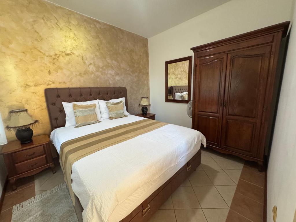 a bedroom with a large bed and a wooden cabinet at Apartments Popovic 2 in Kotor