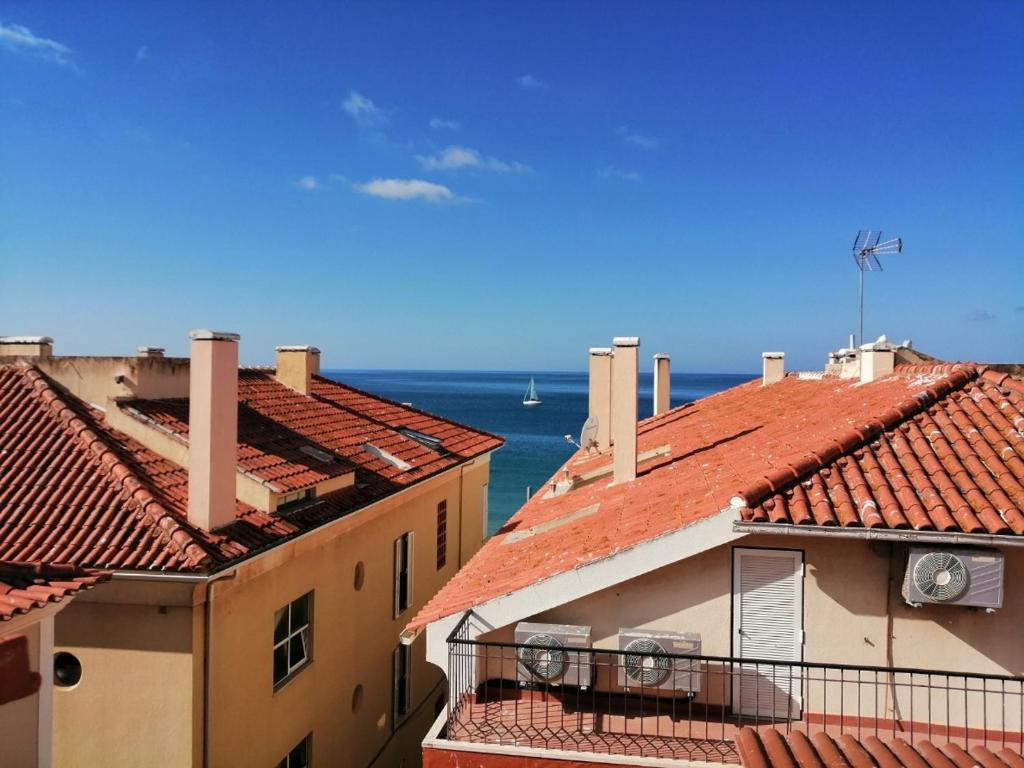 a view of the ocean from the roofs of buildings at Old Town Apt with Ocean Views in Sesimbra
