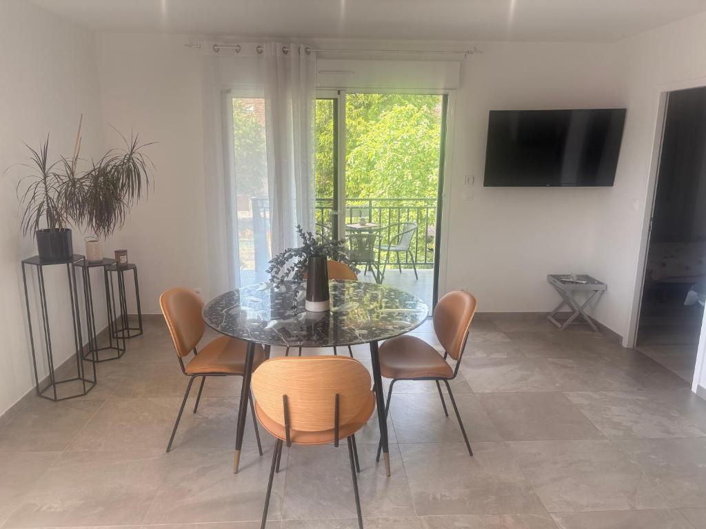 a dining room with a glass table and chairs at Chez sana in Saint-Dizier