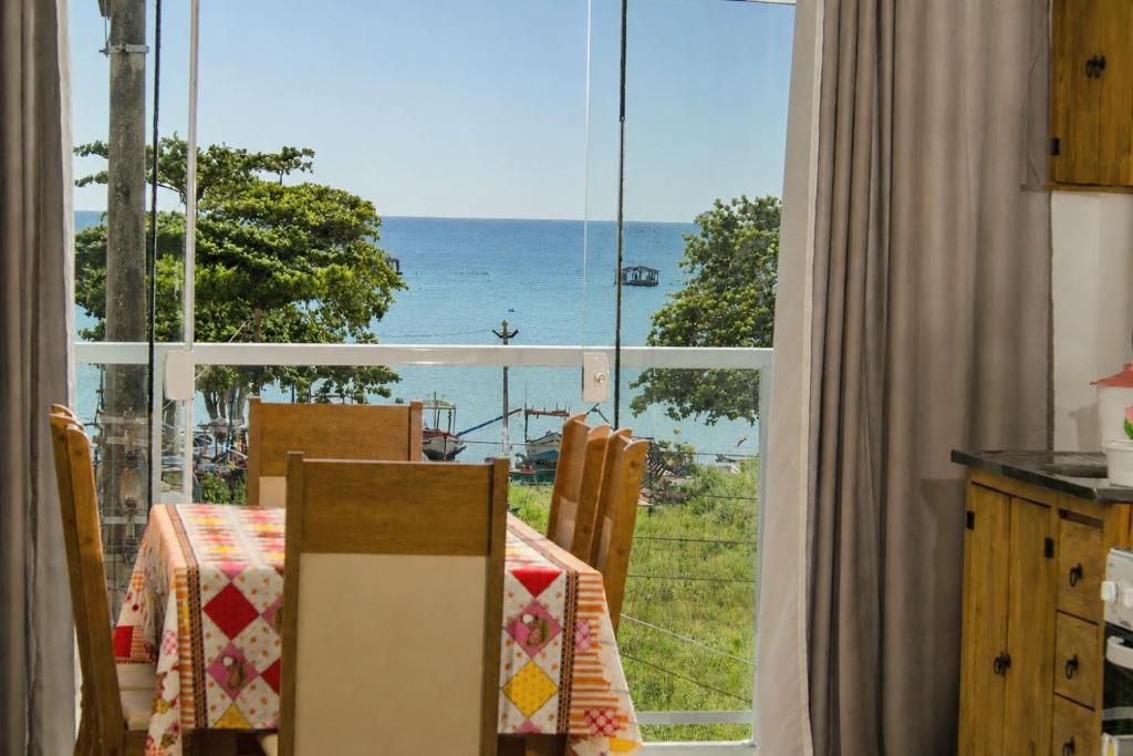 a table with a view of the ocean from a window at Apartamentos Sinhá in Penha