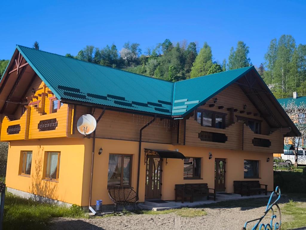 a house with a green roof at Приватна садиба "Гереджука" in Vorokhta