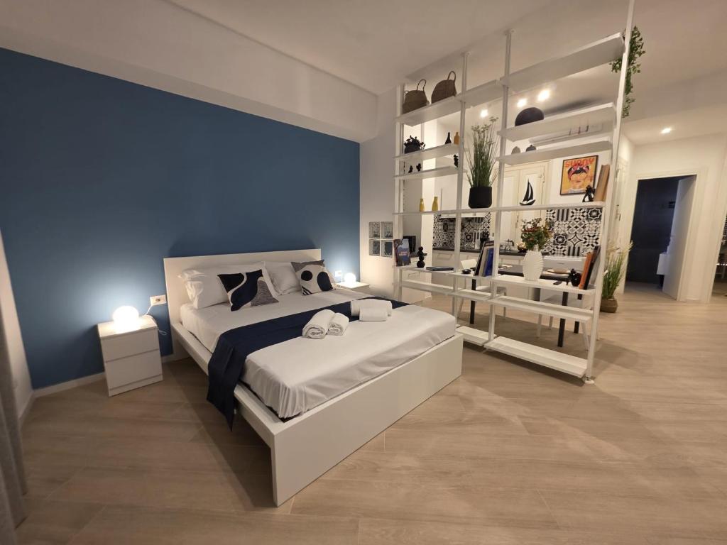a bedroom with a white bed and a blue wall at Townhouse 41 - by Be Your Home in Civitavecchia
