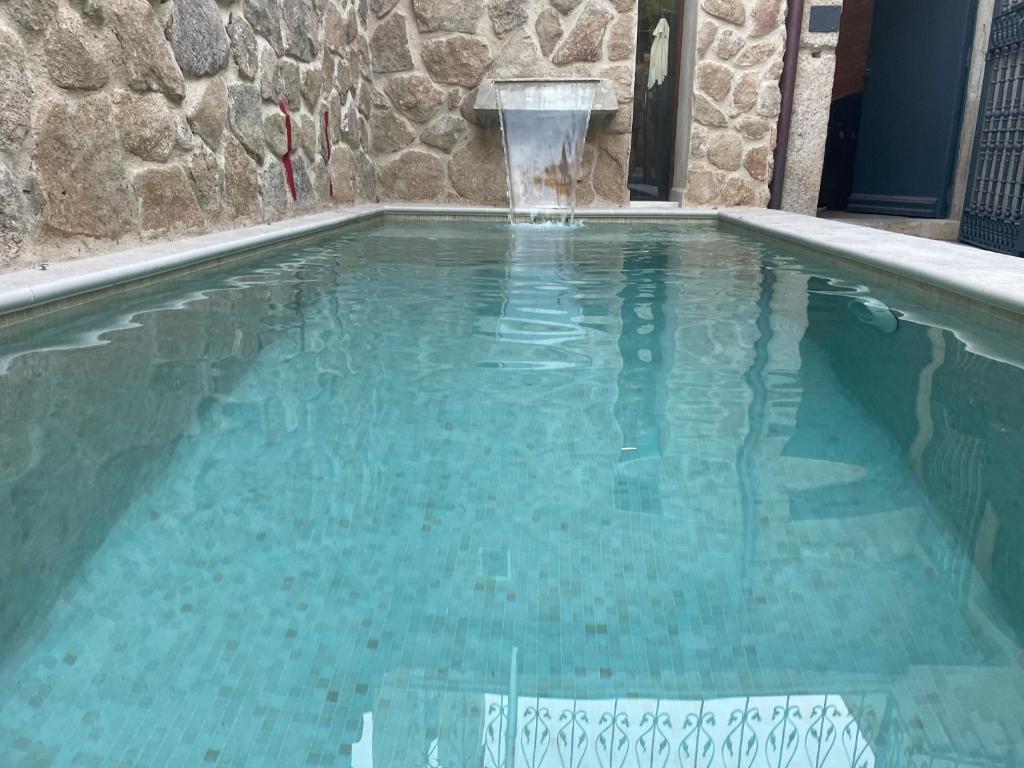 a swimming pool with a water fountain at LA CASONA DE BAUTISTA 4 estrellas con piscina montanchez CACERES in Montánchez