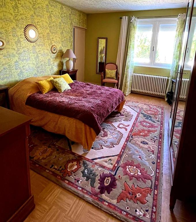 a bedroom with a bed and a rug at Villa Tronçais in Saint-Bonnet-Tronçais