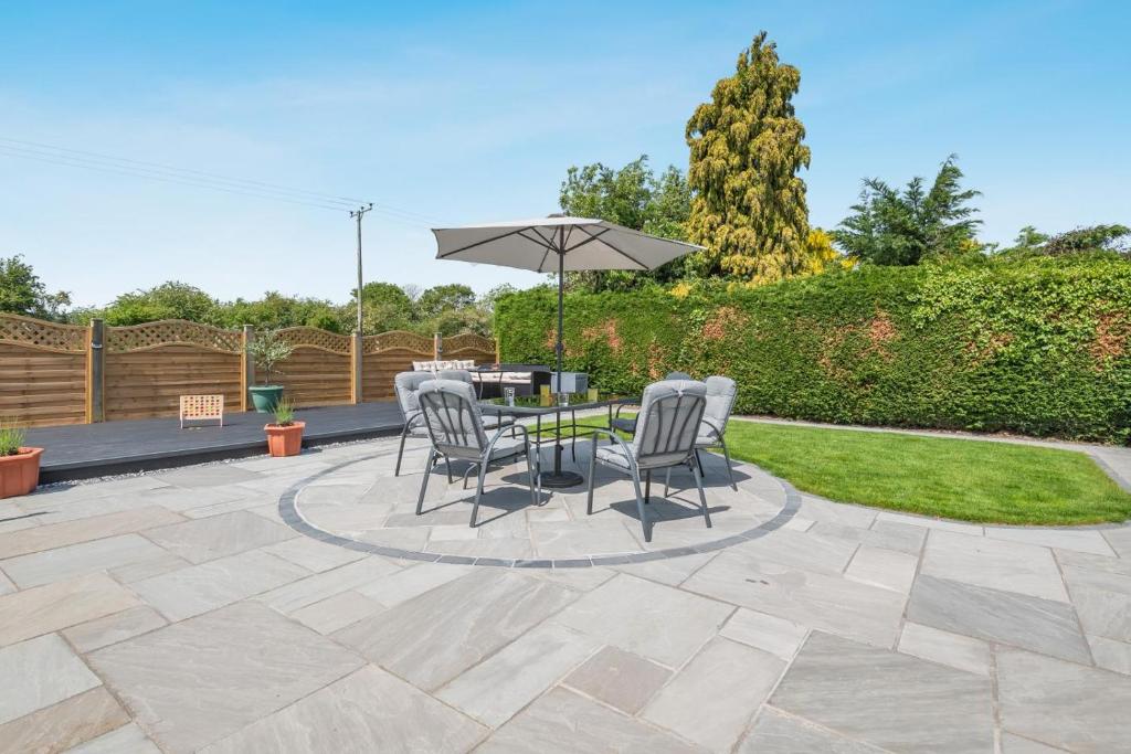 a patio with a table and chairs and an umbrella at 3 Bed in Skegness oc-b33460 in Orby