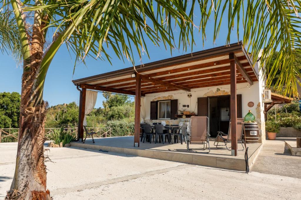 a house with a wooden pavilion with a palm tree at Casa Villa Aury in Cefalù