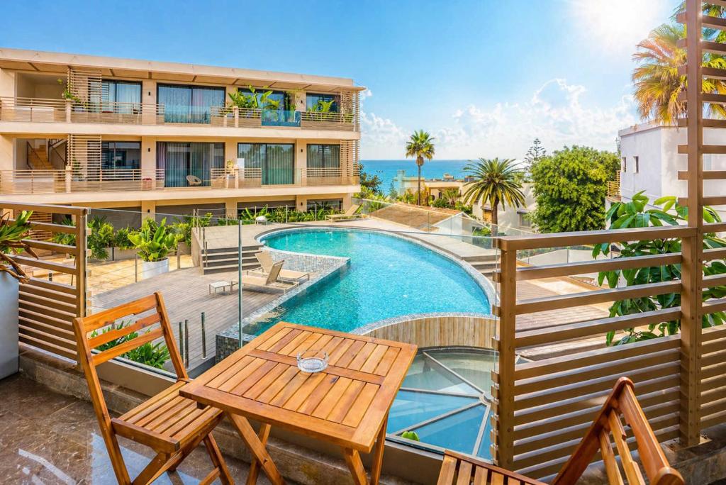 a balcony with a pool and a table and chairs at The Iconic Spot - Pool and Sea View in Anfa-Supérieur