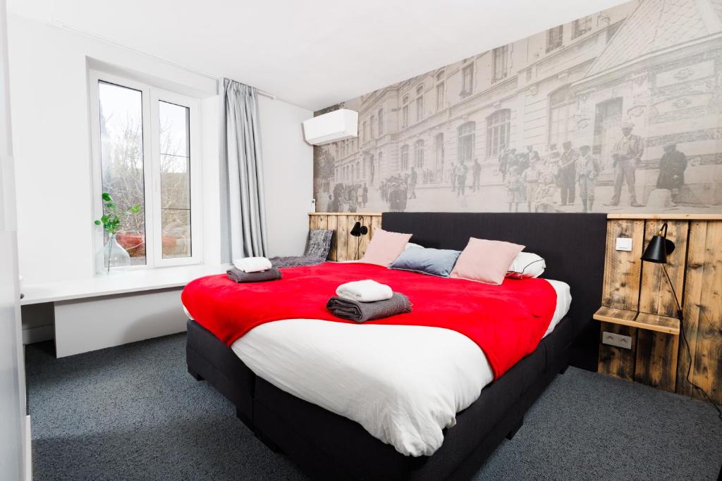 a bedroom with a large bed with a red blanket at Vins de Dagne in Montlaur