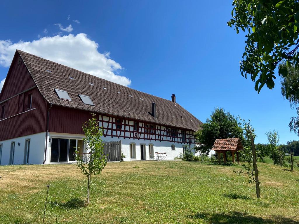 a large red barn with a large gambrel roof at Hofgut Breitenbach in Markdorf