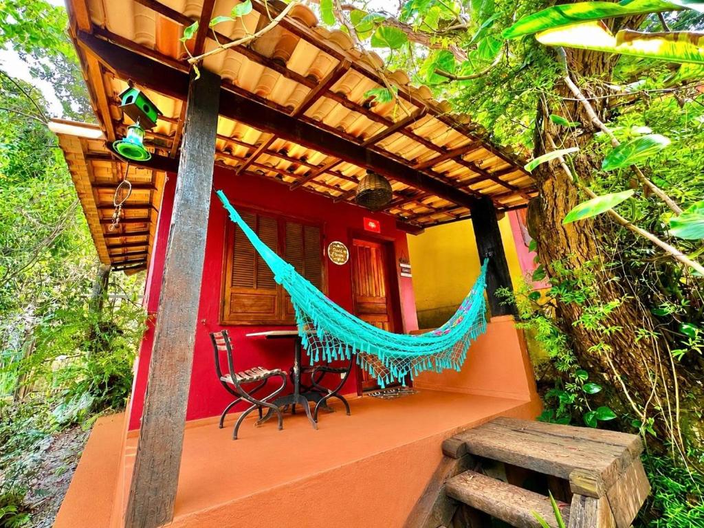 a house with a hammock in front of it at Chalé das Flores in Brumadinho