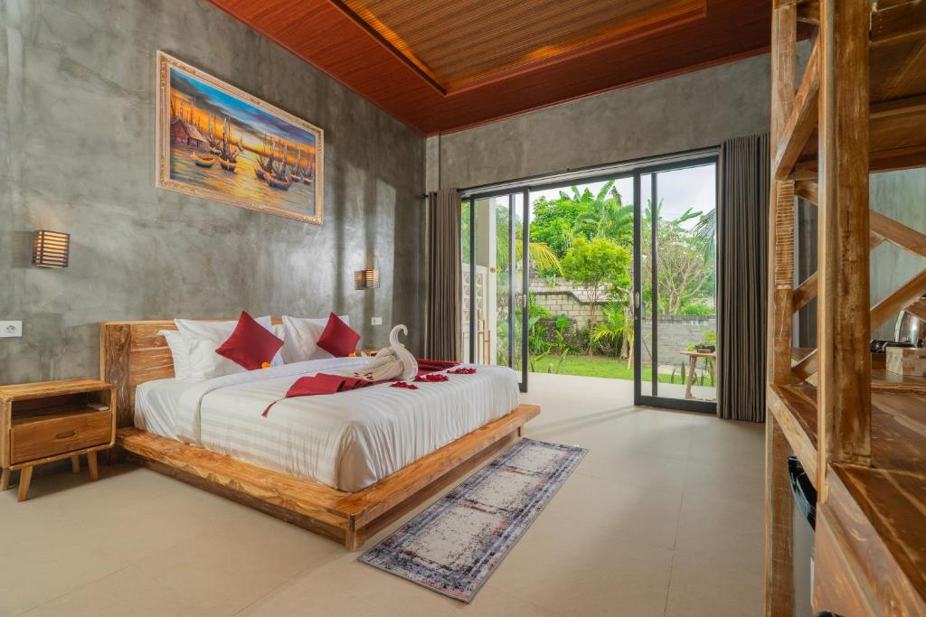 a bedroom with a large bed and a large window at Kamasan Nusa Penida By Reccoma in Nusa Penida