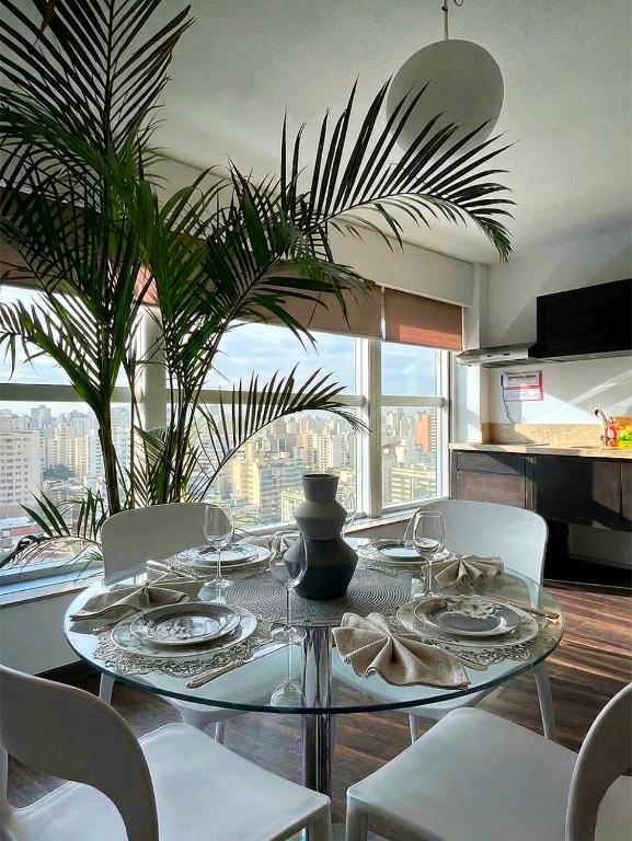 a dining room table with white chairs and a plant at MySuites in Montevideo