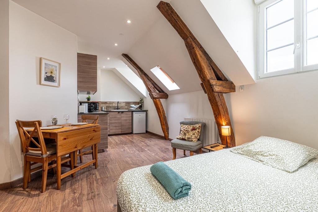 a bedroom with a bed and a desk and a kitchen at Murray - En plein cœur de Caen in Caen