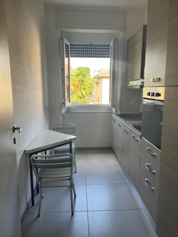 a kitchen with a table and a table and a window at Casa Vacanza Giorgio Apartment in Gallarate