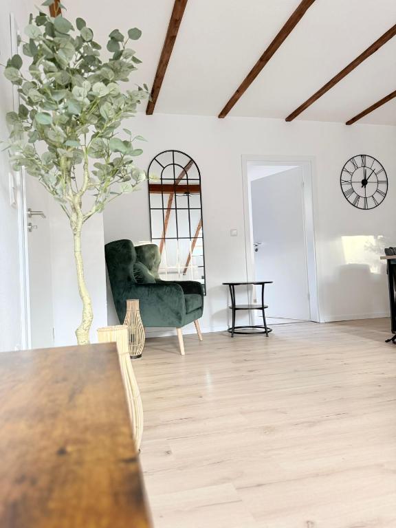 a living room with a green chair and a table at Heyne-Ufer City Apartment II - TOP Innenstadtlage in Göttingen