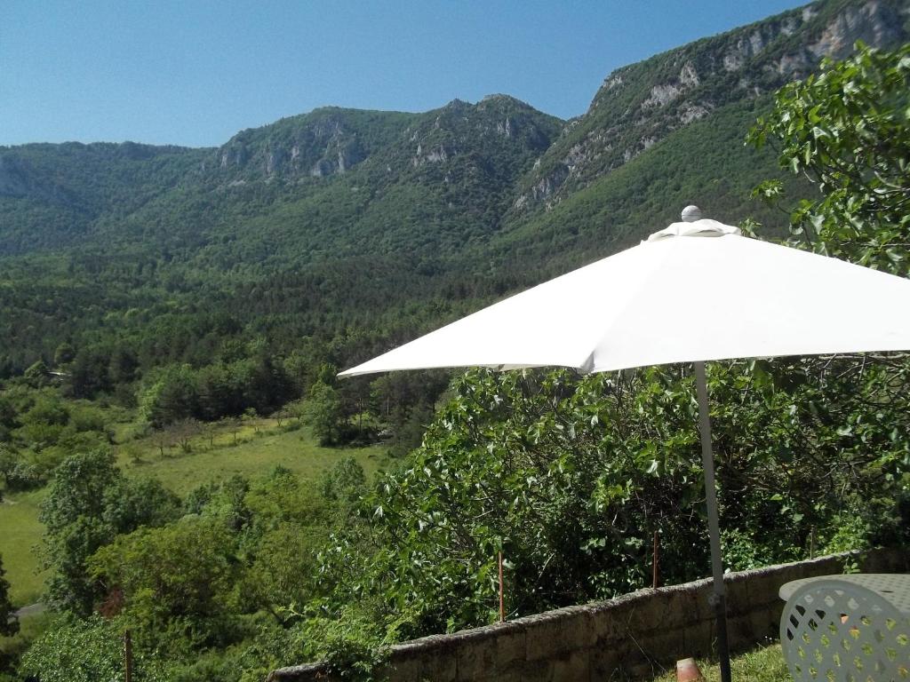a white umbrella sitting on a ledge with a mountain at Le Bel Coin in Ginoles