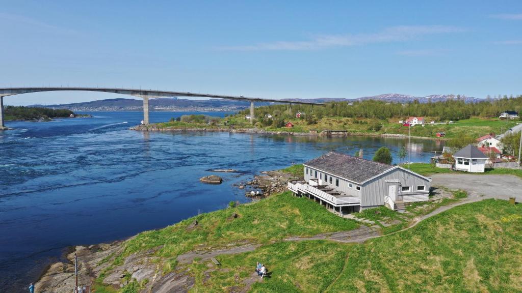 a house on an island with a bridge in the background at Kystbua 360 in Saltstraumen