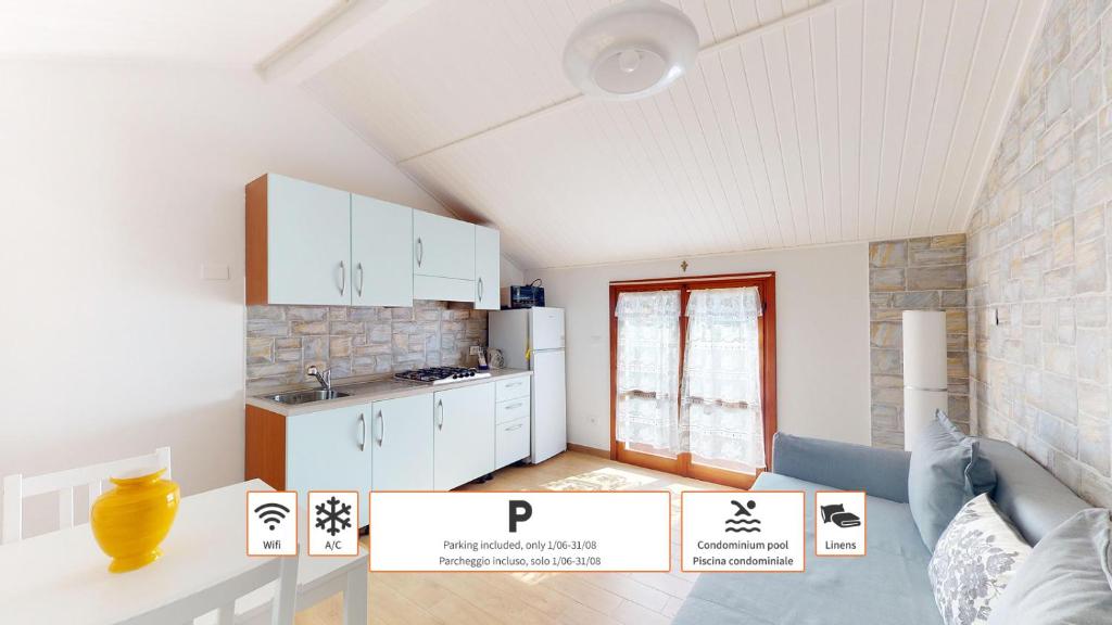 a kitchen with white cabinets and a table in a room at CliVio - By Ligooria in Pietra Ligure