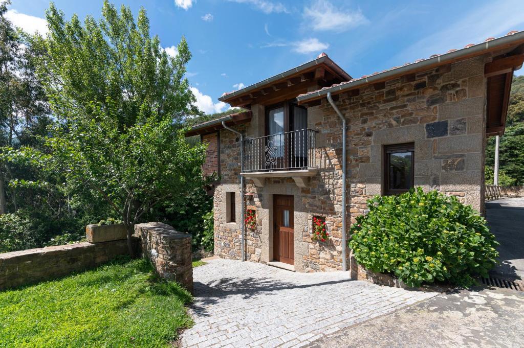 a stone house with a balcony and a driveway at Fidalsa Paradise Point in Cabezón de Liébana