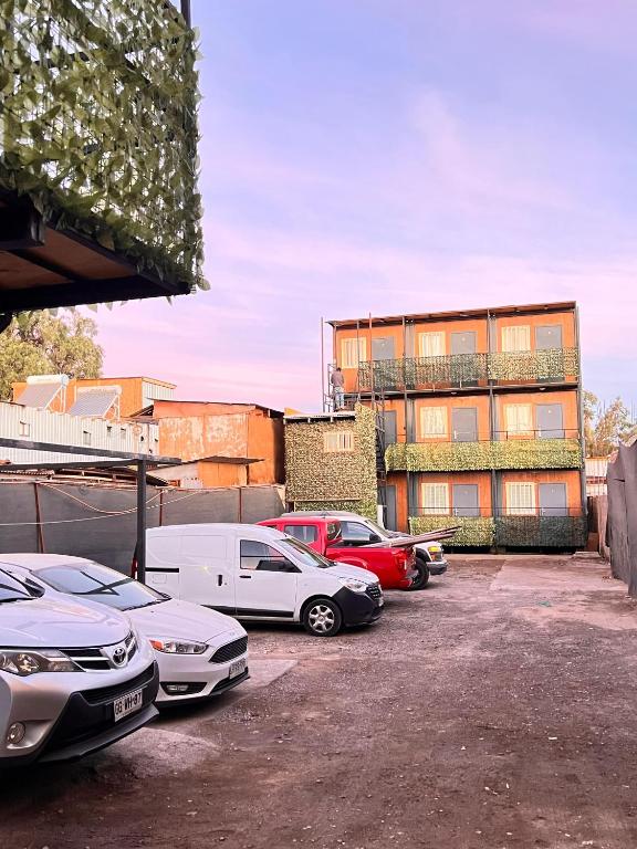 a parking lot with cars parked in front of a building at Hospedaje Oasis Modulares in Calama