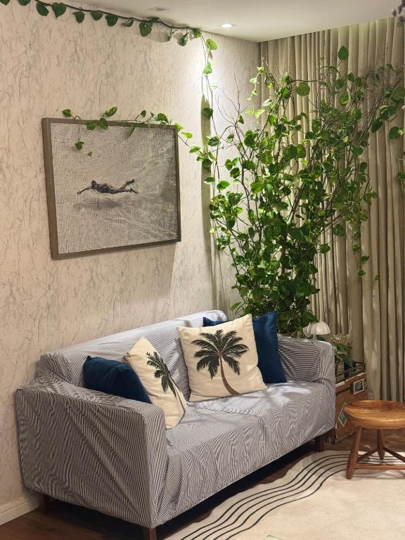 ein Wohnzimmer mit einer grauen Couch und Kissen in der Unterkunft Flat gp moto in Goiânia