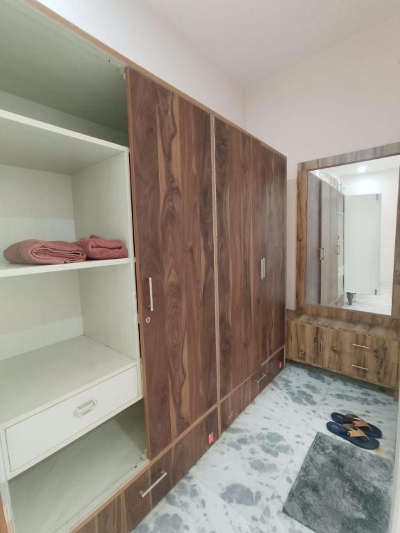 a room with wooden cabinets and a mirror at Om Homestay in Panchkula