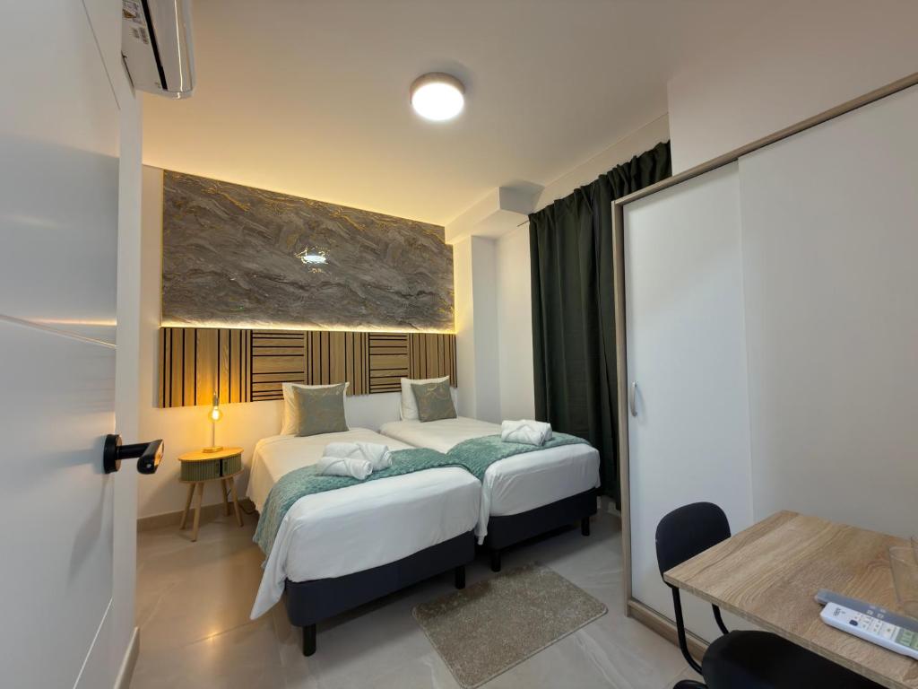 a bedroom with two beds and a table and a door at Hotel Boutique Traveler 360 in Madrid