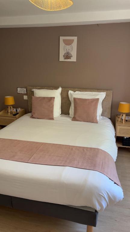 a bedroom with a large bed with two pillows at Hôtel Comme chez soi in Jas