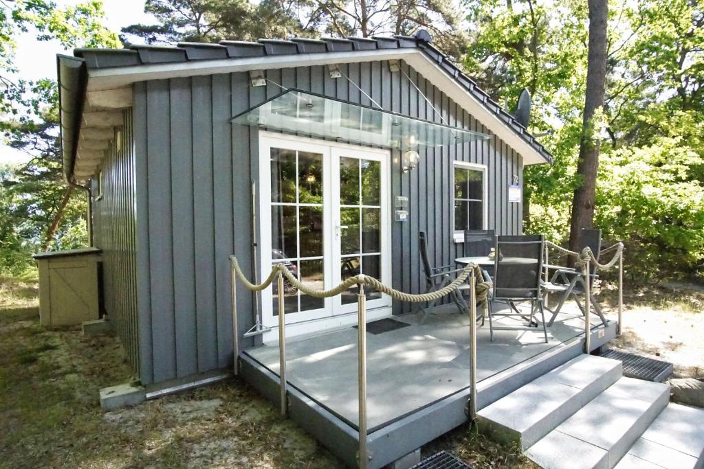 a tiny house with a porch and a table at Chalet Ostsee Nr 72 in Göhren