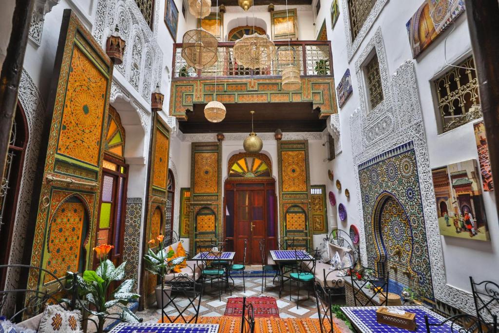 a hallway of a building with tables and chairs at Riad Zayna Fes in Fez