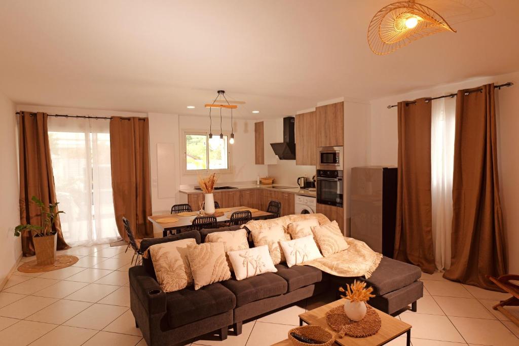 a living room with a couch and a kitchen at Ti Kaz des Roches in Saint-Louis