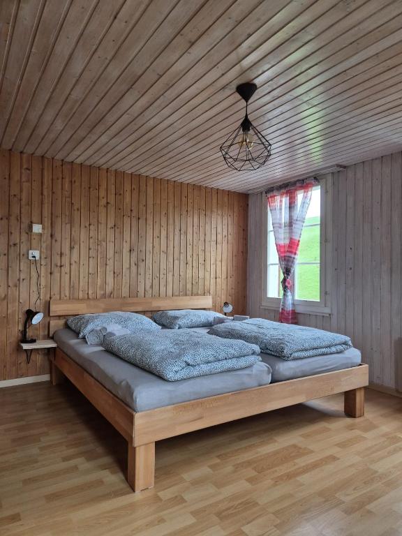 a bedroom with a large bed with a wooden ceiling at Gemütliche Wohnung im Grünen in Herisau