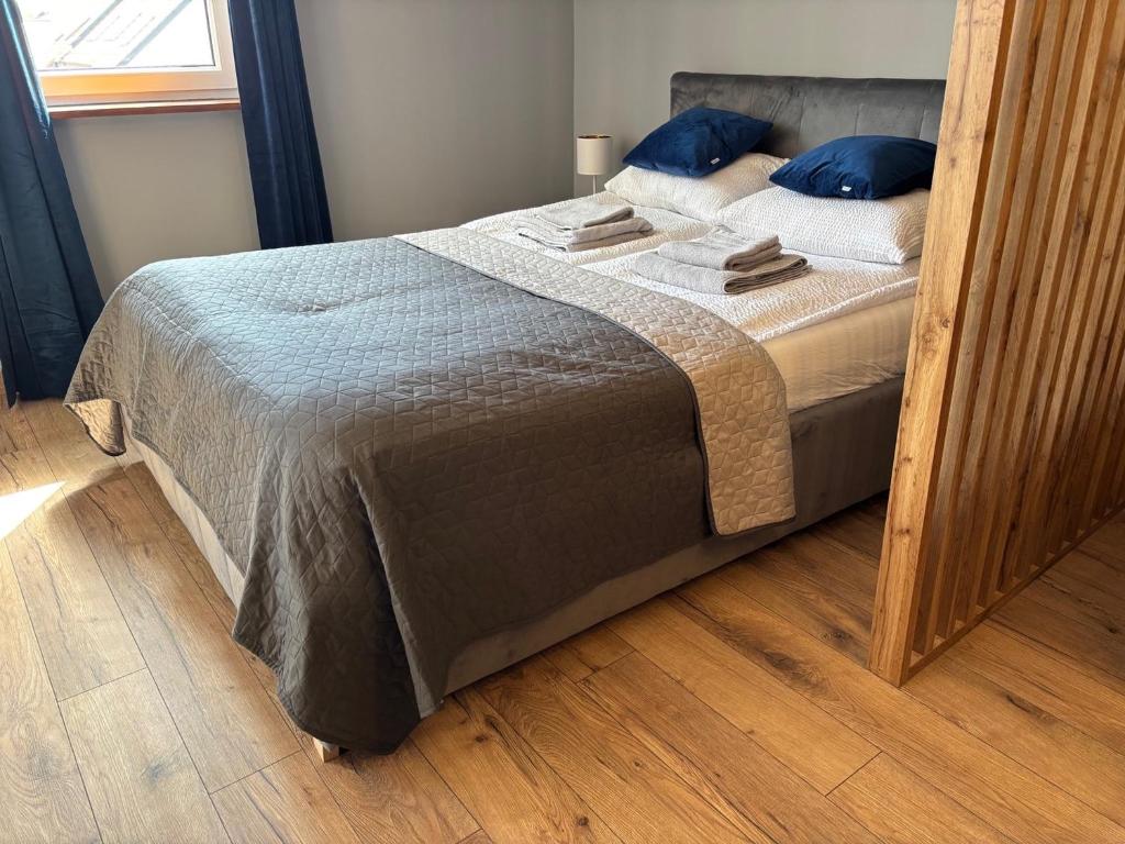 a bedroom with a bed with blue pillows on it at Apartament Nova Starówka 2 in Konin