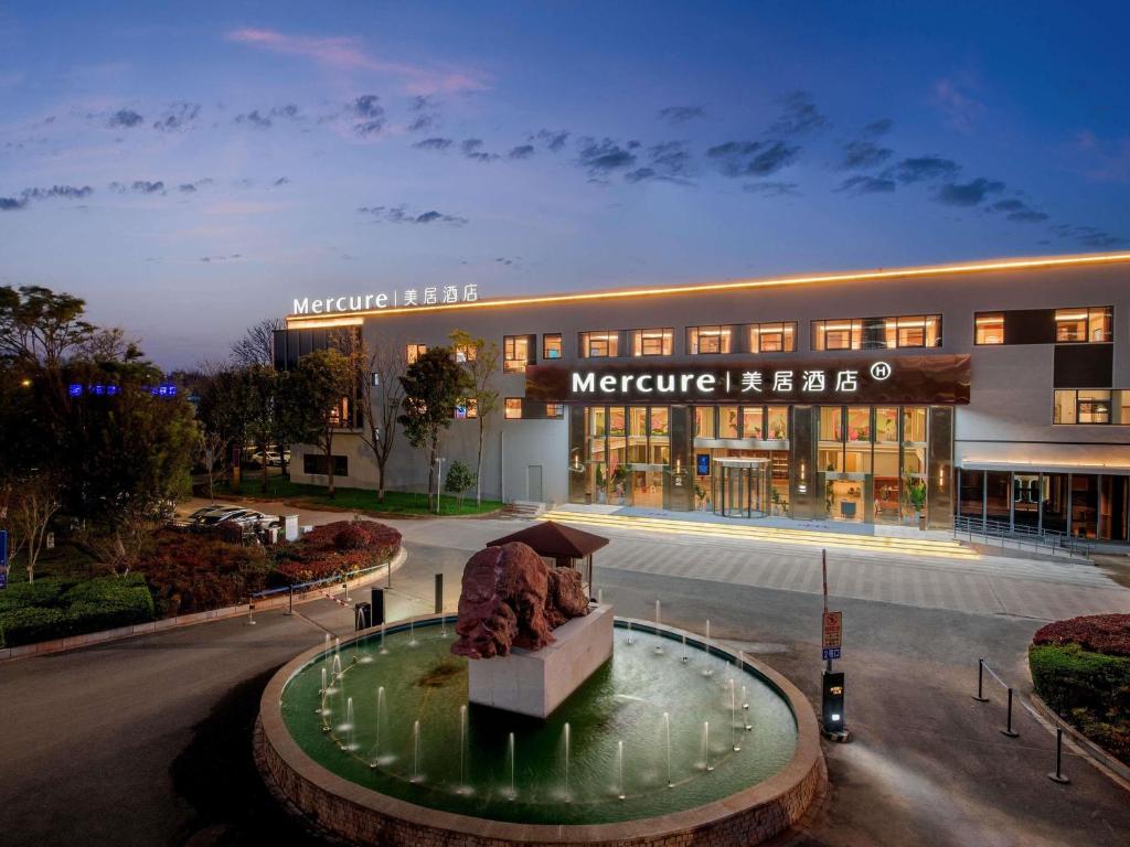 a large building with a fountain in front of it at Mercure KunMing Airport in Kunming