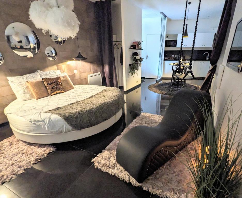 a bedroom with a bed and a chair in it at Le Lovt - LOVE ROOM NANTES in Nantes