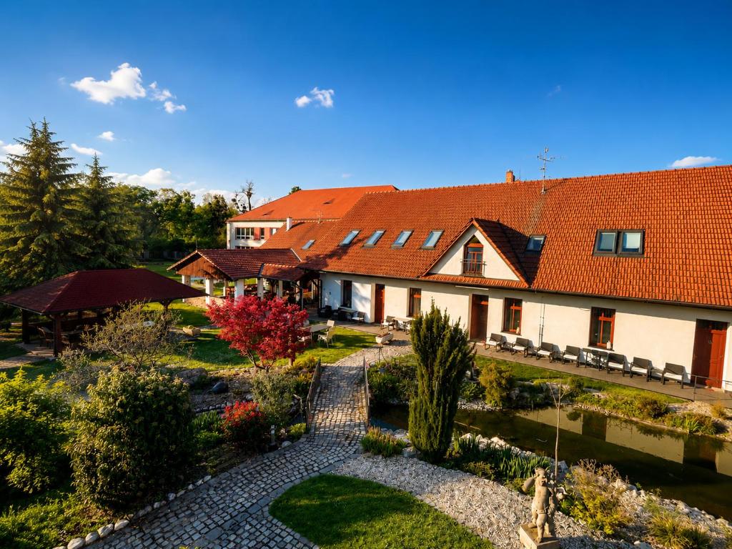 a house with a red roof and a garden at Penzion U Bohuša in Lednice