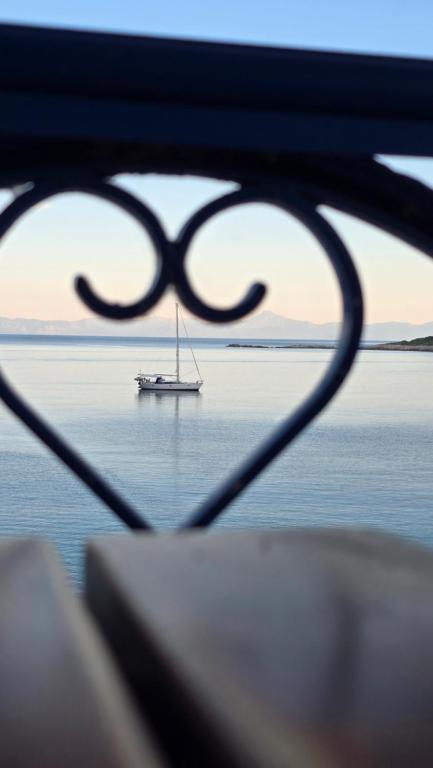 ein Segelboot im Wasser mit einem Boot im Ozean in der Unterkunft Nostos in Patitiri